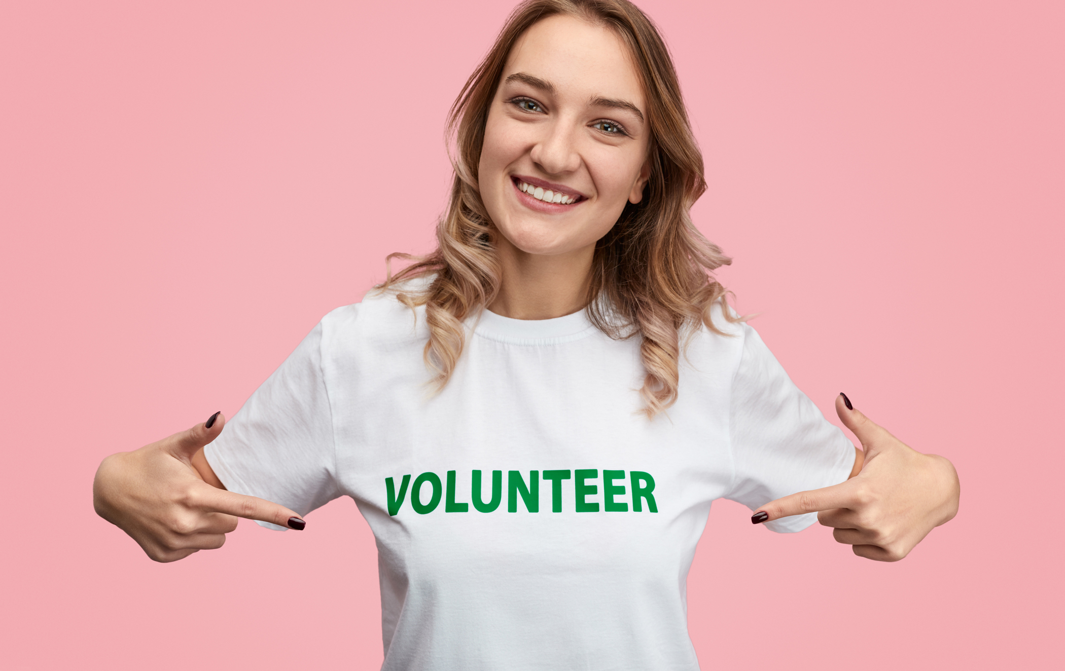 Smiling woman pointing at volunteer writing